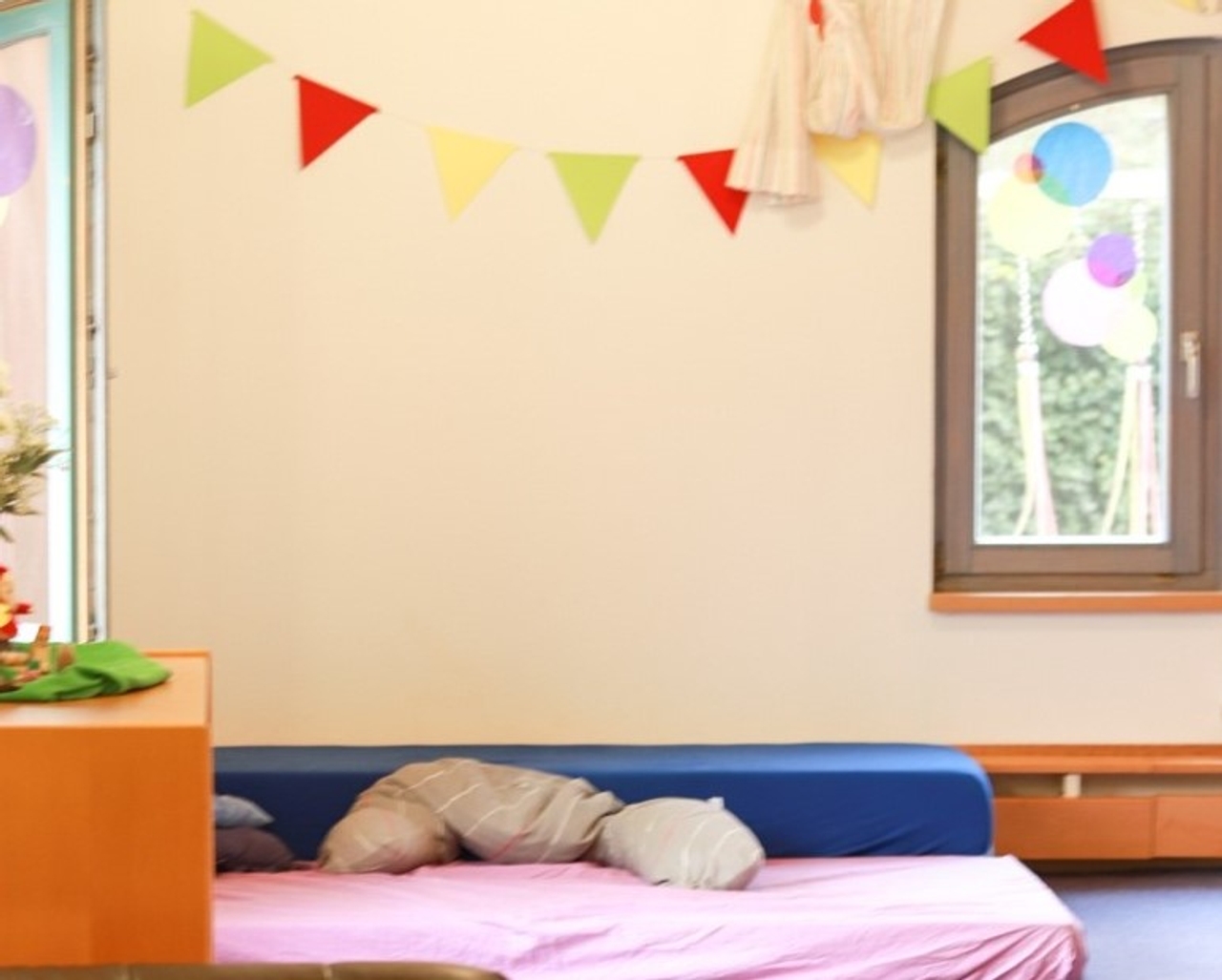 Eine bunte Girlande über einer Matratze.