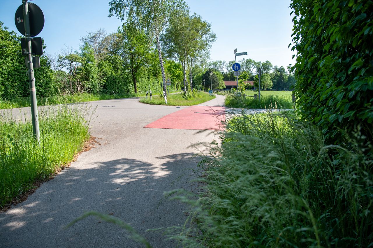 Blick entlang des Fahrradweges am Zillerhof mit einer roten Fahrradfuhrt über die einmündende Straße
