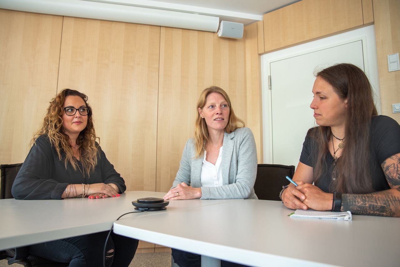 Drei Mitarbeiterinnen der Gemeinde führen konzentriert eine Telefonkonferenz und machen sich Notizen