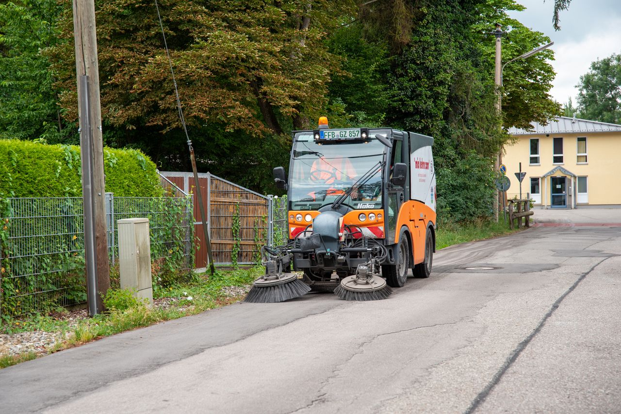 Kleine Kehrmaschine kehrt den rechten Rand einer Straße