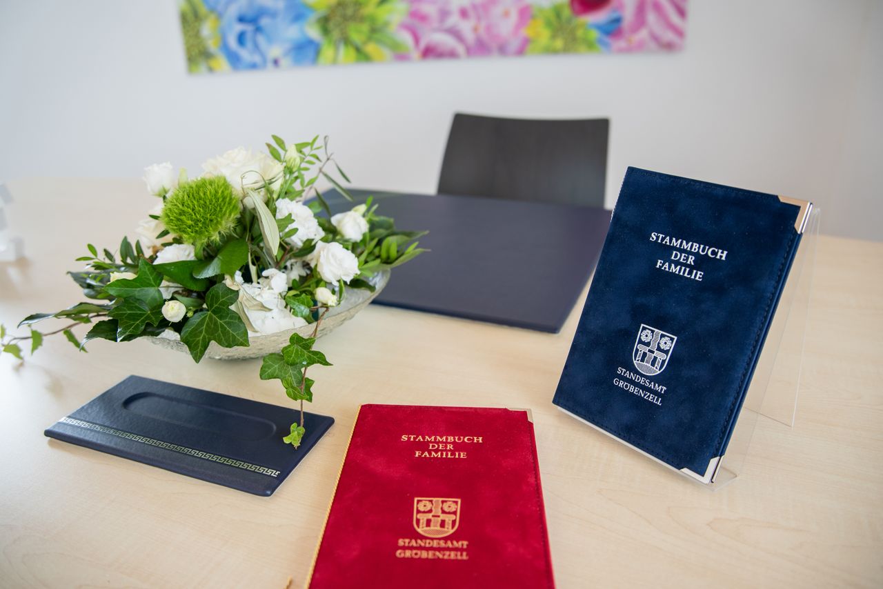 Stammbücher zur Trauung liegen neben einem Blumengesteck auf einem Tisch im Trauungszimmer