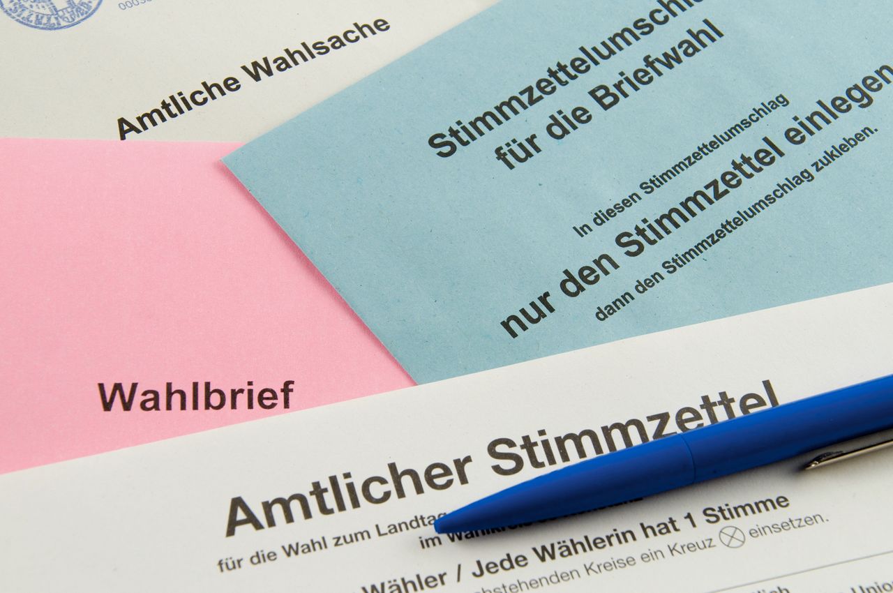 Amtliche Stimmzettel liegen aufeinander, mit einem Stift auf dem Tisch
