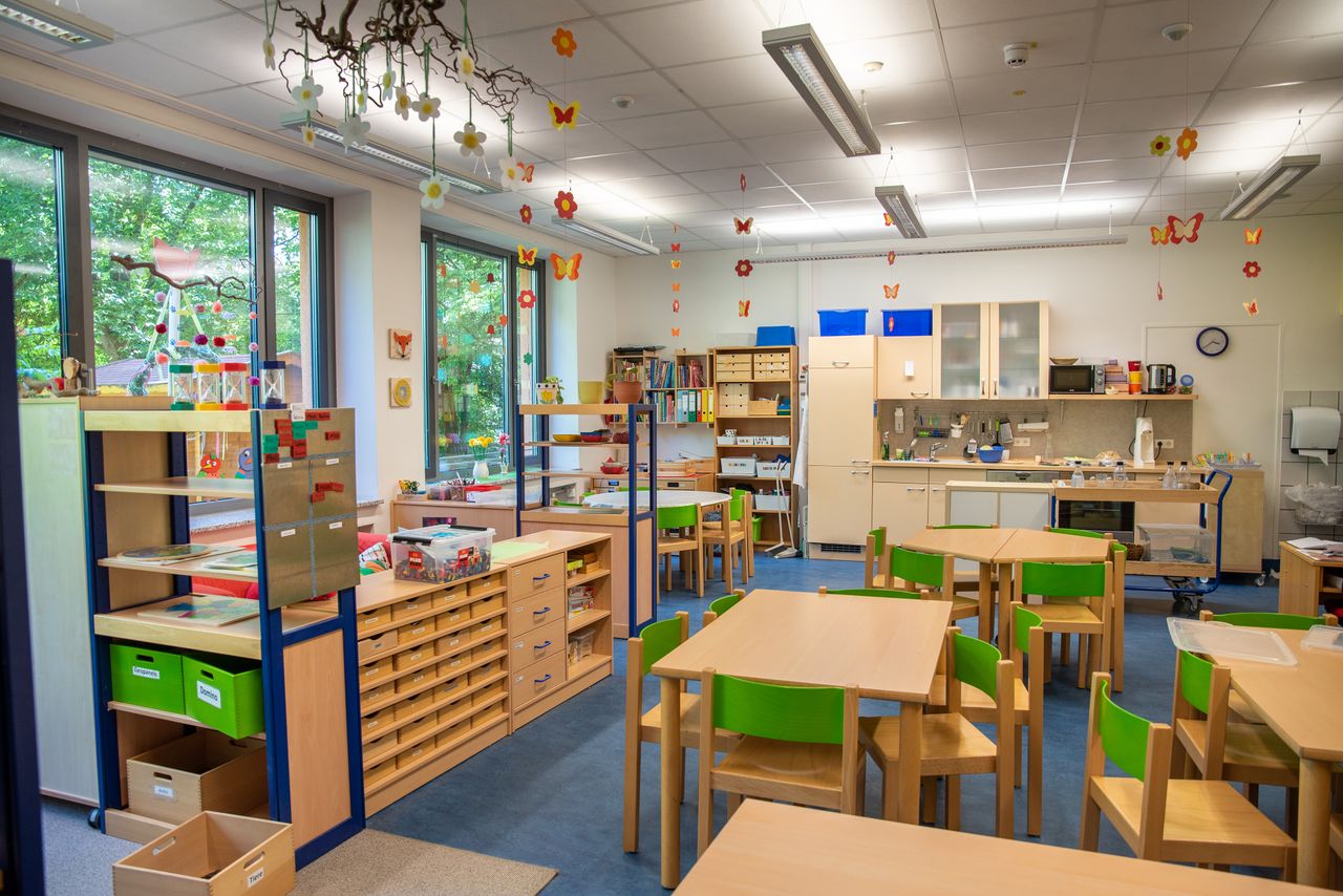 Ein Gruppenraum im Kindergarten Ährenfeldfüchse, links eine Lese- und Spielecke, im Hintergrund eine Küchenzeile
