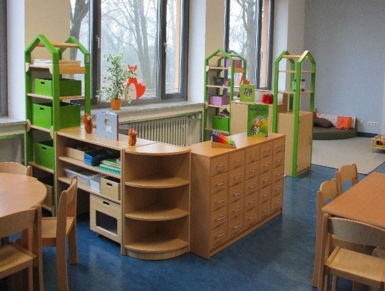 Eine Kinderecke mit Schränken, Tischen und Stühlen