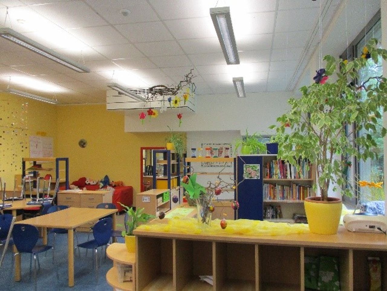 Bunter Raum mit Stühlen und Regalen