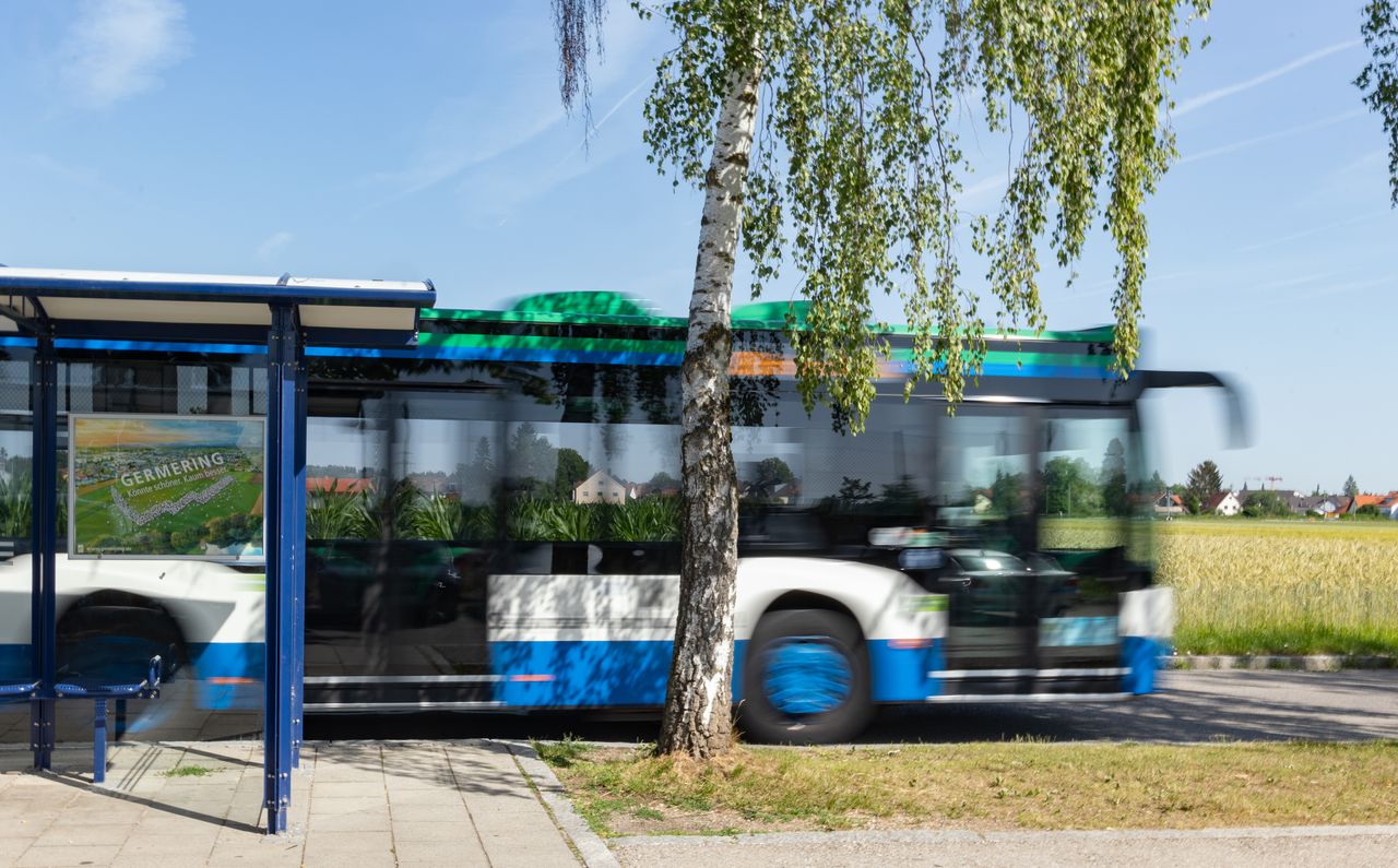 MVV-Bus hält an der Haltestelle "Kreuzlinger Feld" - erkennbar im ländlichen Raum, im Hintergrund ein Feld.