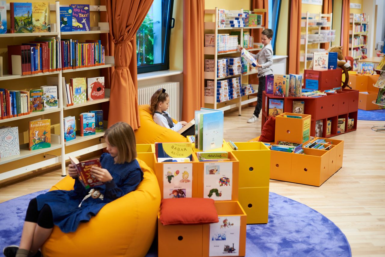 Kinderecke in der Gemeindebücherei Kinderecke und -bereich in der Bücherei, darin drei Kinder