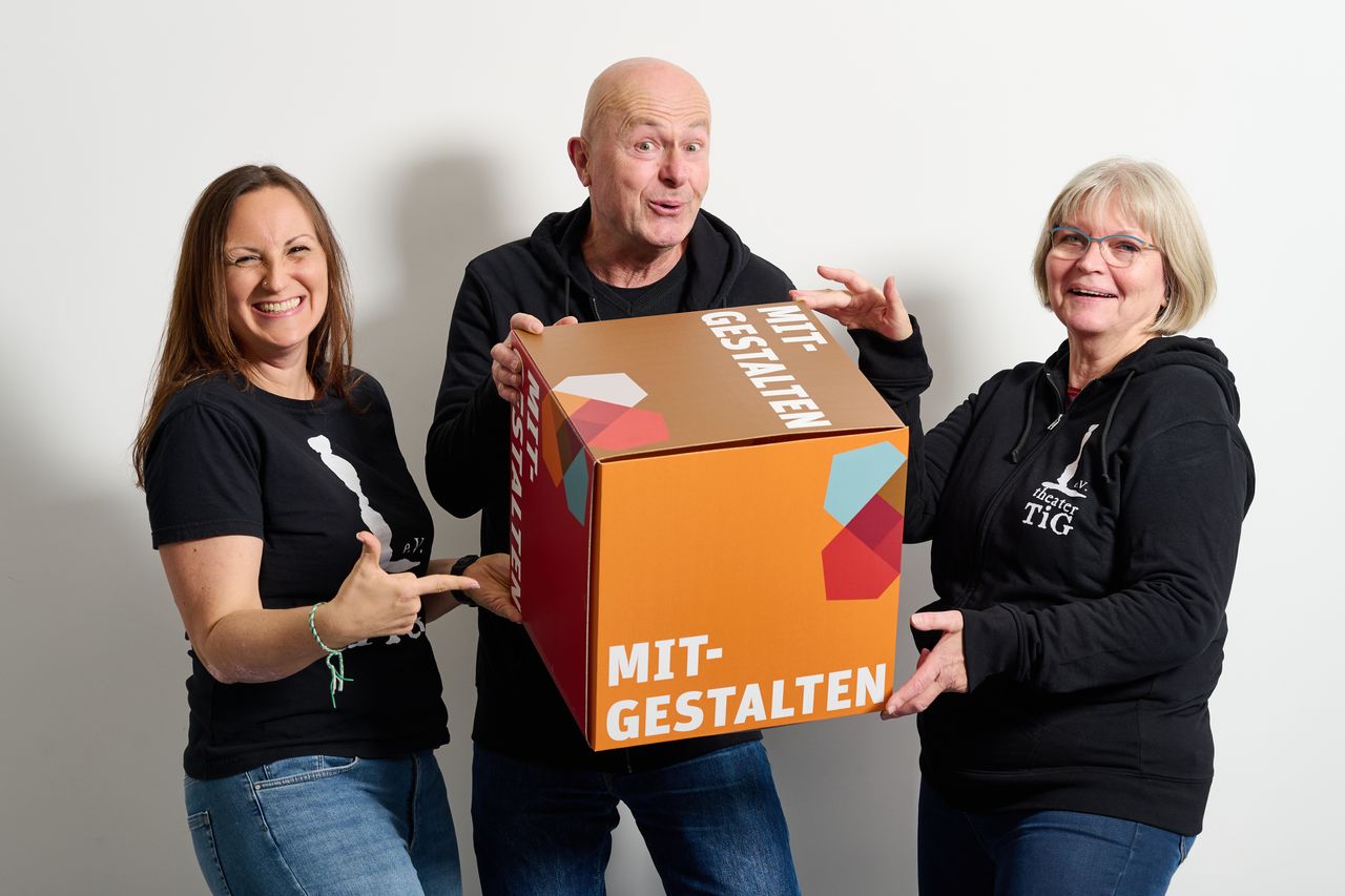 Drei Personen halten Würfel mit "Mitgestalten" in der Hand