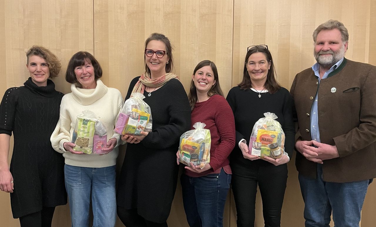 Mehrere Personen stehen nebeneinander und halten Präsente 