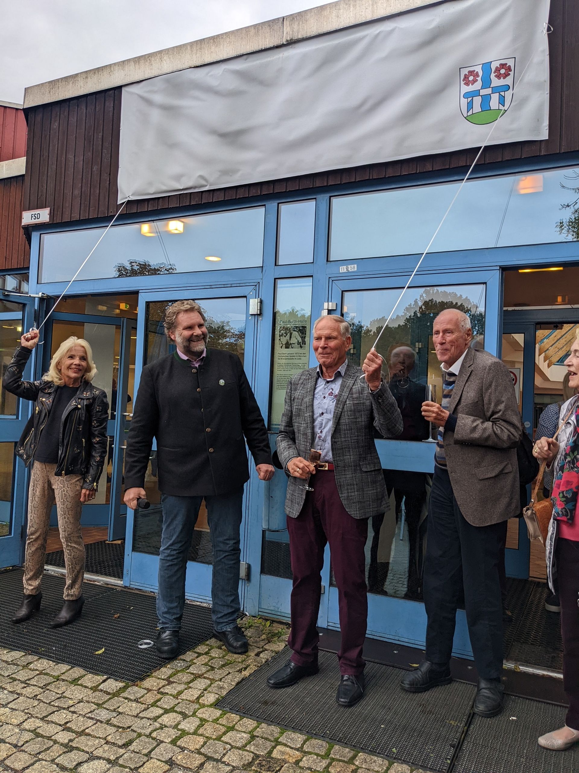 Dreifachturnhalle heißt „Paul-Barth-Halle“ v.l.n.r.: Evi Barth (Ehefrau), Martin Schäfer (Erster Bürgermeister), Paul Barth und Dr. Eicke Götz (ehem. Bürgermeister Gröbenzells) bei der Enthüllung des Schildes.