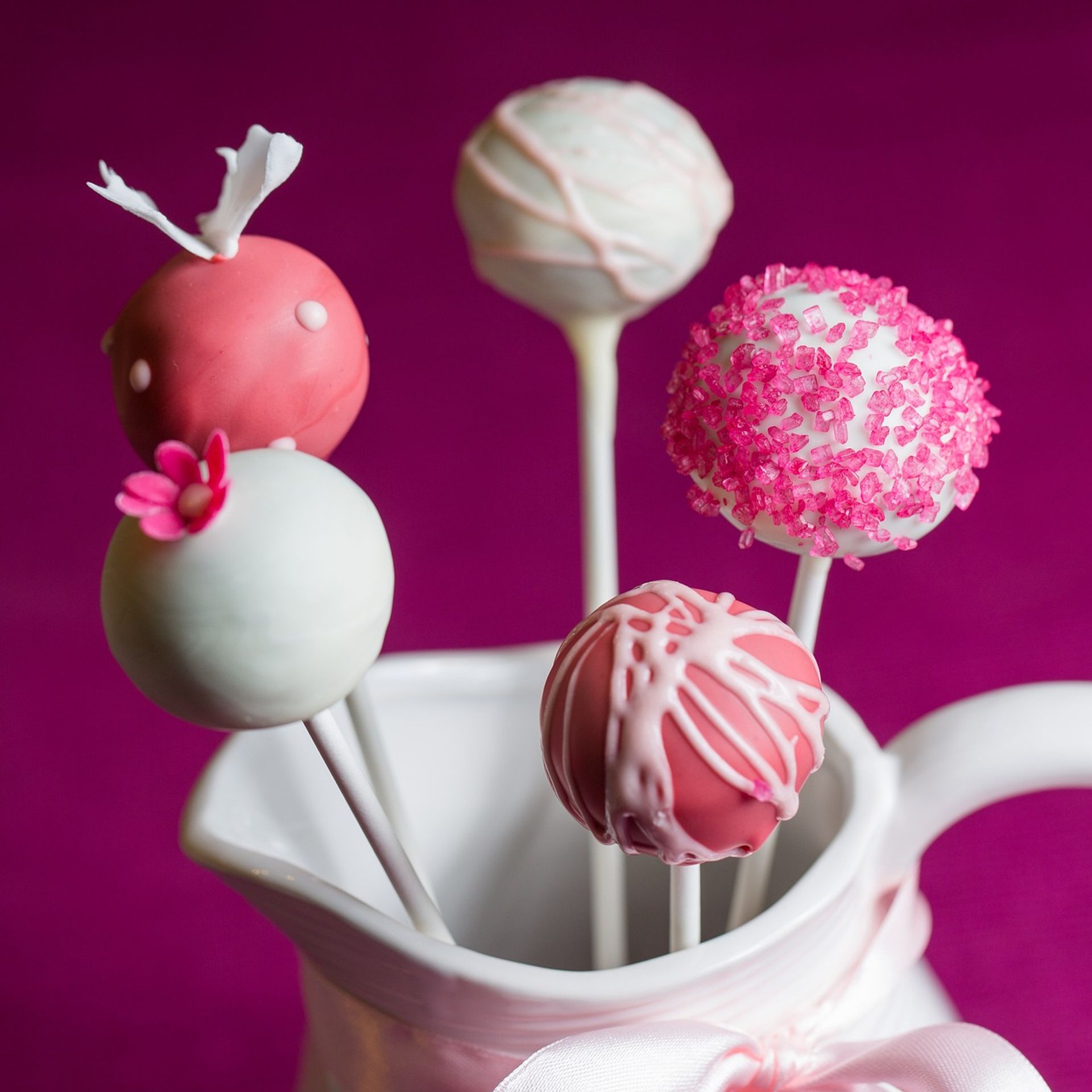 Fünf verschiedene verzierte Cakepops in einer weißen Kanne