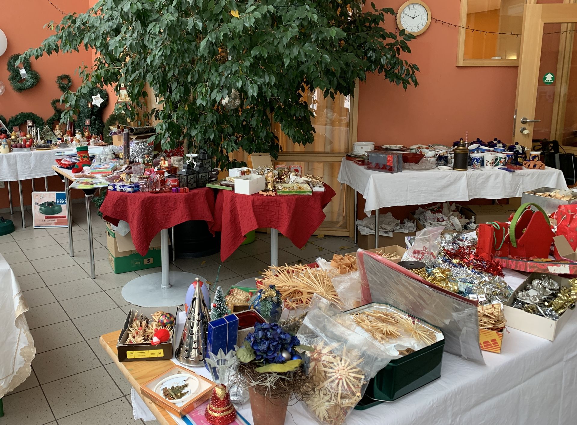 Tische mit Christbaumschmuck und Weihnachtsdeko.