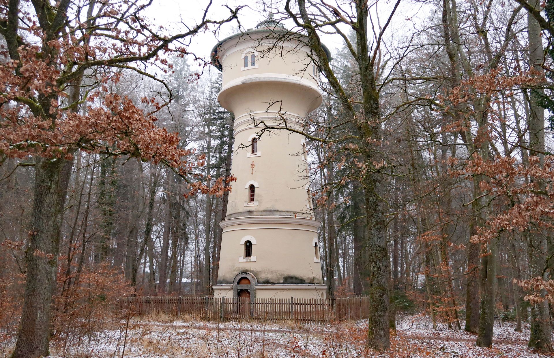 Bild eines Wasserturms in einem Wäldchen, Schnee bzw. Reif liegen