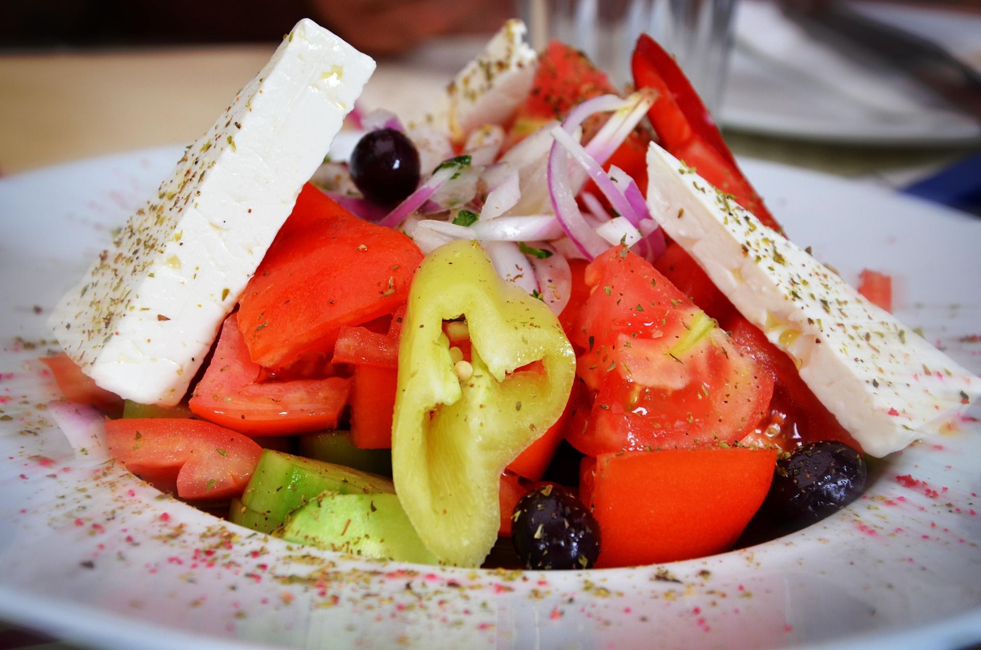 Foto eines griechischen Salats mit Paprika, Oliven, Zwiebeln, Tomaten und Feta