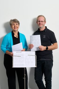 Zwei Personen mit Notenblatt