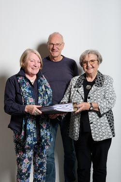 Drei Personen halten einen Aktenordner