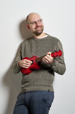 Musiker steht mit seiner Ukulele
