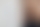 Junge Geschäftsfrau steht neben Whiteboard und lächelt in die Kamera. Auf dem Whiteboard sind Notizen und die Spiegelung der Person zu sehen.