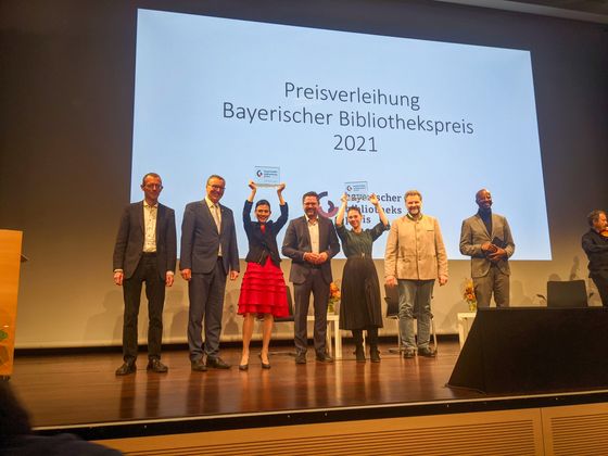 Die Preisträger des ersten Bayerischen Bibliothekspreises 2021 - v.l.n.r.: MR Dr. Dirk Wintzer (Verleihung des Preises i.V. des Staatsministers), Jürgen Götz (Erster Bürgermeister Veitshöchheim), Dr. Astrida Wallat (Büchereileitung Veitshöchheim), Dr. Gerhard Hopp (MdL, Vorsitzender Bayerischer Bibliotheksverband und Jurymitglied), Angelina Hanke (Büchereileitung Gröbenzell), Martin Schäfer (Erster Bürgermeister Gröbenzell), Yared Dibaba (Moderator).