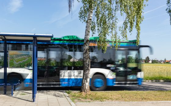 MVV-Bus hält an der Haltestelle "Kreuzlinger Feld" - erkennbar im ländlichen Raum, im Hintergrund ein Feld.