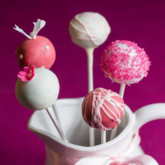 Fünf verschiedene verzierte Cakepops in einer weißen Kanne