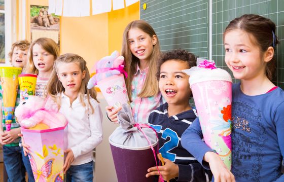 Gröbenzeller Schultütenzauber 2025 Sechs Erstklass-Kinder stehen mit ihren Schultüten vor der Tafel und lachen in die Kamera.