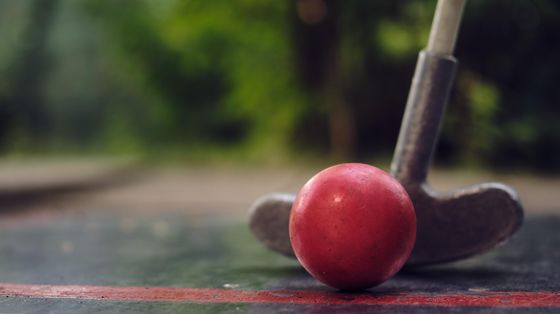 Mit dem Radl zum Minigolf (Kinderprogramm Impuls) Minigolfschläger mit einem roten Ball beim Schlag