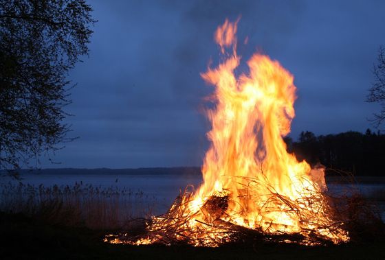 Großes Lagerfeuer an einem Seeufer