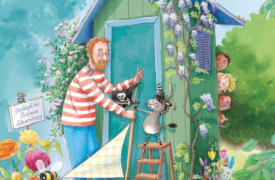 Vor einem grünen, mit Pflanzen bewachsenen Gartenhaus hissen ein Mann im rot-weißen Ringelpullover und ein kleiner Esel auf einer Trittleiter ein Segel mit Piratenflagge. Hinter dem Gartenhaus spähen drei Kinder und ein Teddy hervor.
