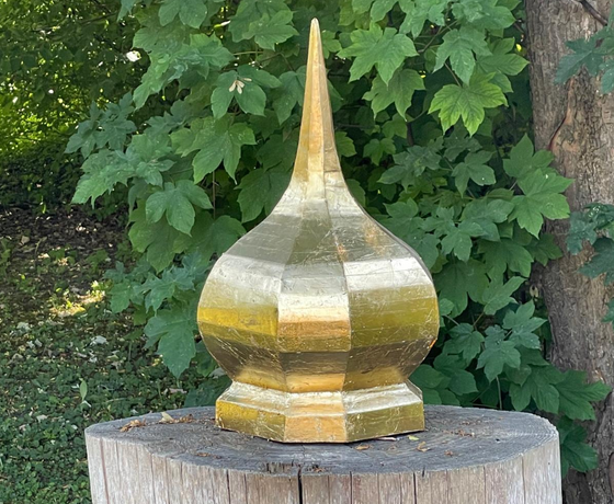Vergoldete Holzplastik auf Holzblock im Garten
