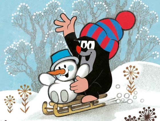 Der kleine Maulwurf  mit einer blau-roten Pudelmütze rodelt mit einem Schneemann mit blauem Hut den Hügel hinab.