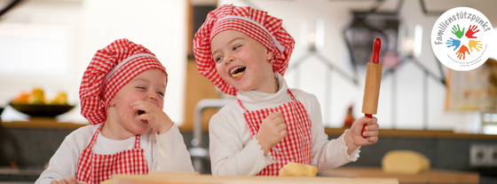Zwei lachende Kinder beim Plätzchenbacken