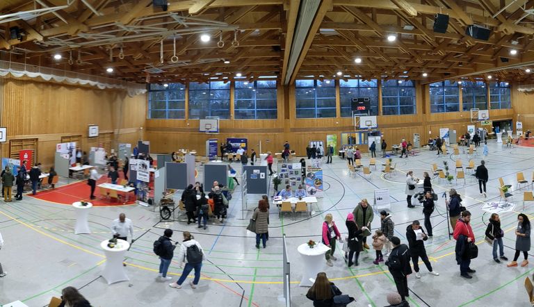 Panorama-Bild von oben: Paul-Barth-Halle mit Ständen und Gästen während des Job-Speed-Datings 2024, rege Betriebsamkeit