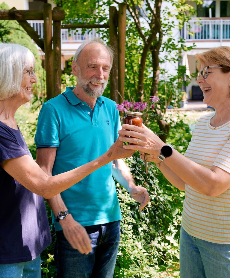 Nette Nachbarn übergeben Marmelade über den Gartenzaun