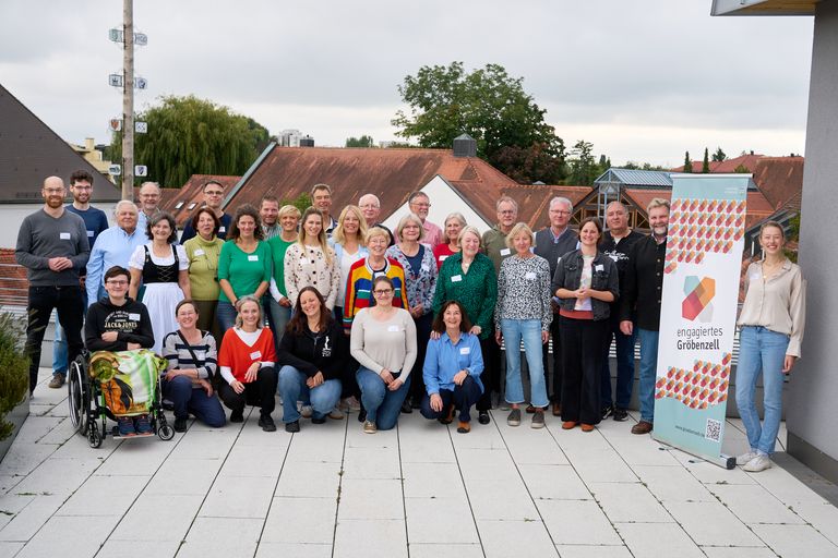 Alle Teilnehmenden sowie Erster Bürgermeister und Ehrenamtskoordinatorin auf einem Gruppenbild am Rathausdach.
